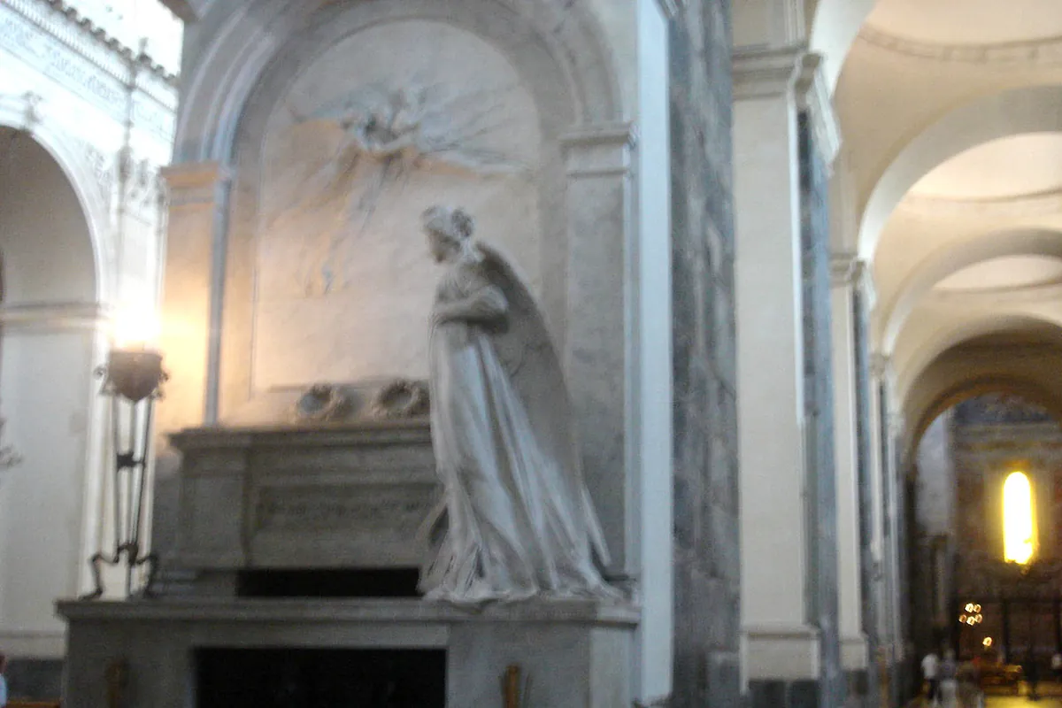 Bellini's marble tomb in Catania Cathedral, with a white figure in a niche on a stone sarcophagus beside a pilaster